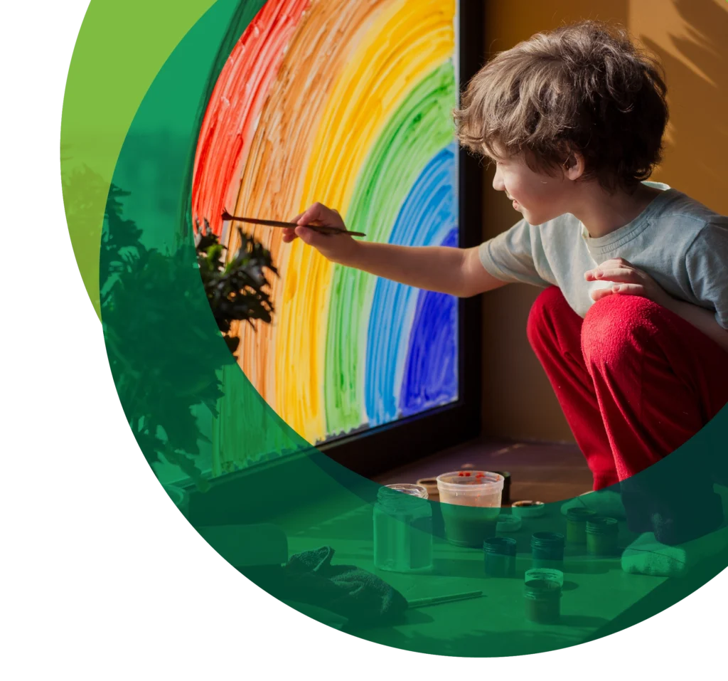 Child painting rainbow on window Community campaigns